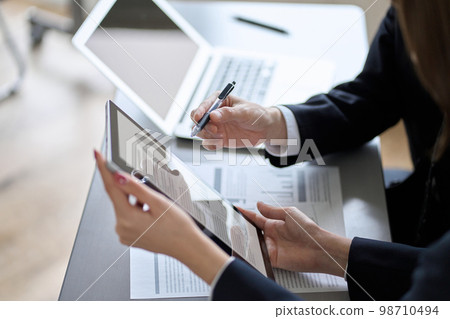 Asian business person having a meeting with a tablet Asian business person having a meeting with a tablet 98710494