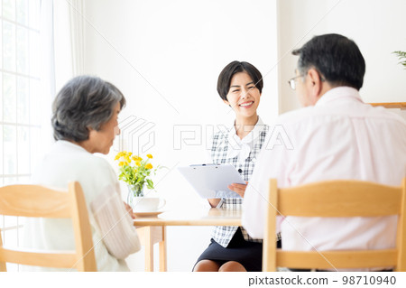 A woman explaining to a senior couple 98710940