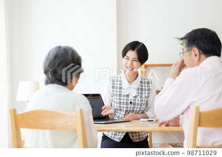 A woman explaining to a senior couple 98711029