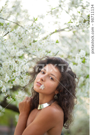 Portrait of a young laughing sexy brunette girl with a necklace around her neck Portrait of a young laughing sexy brunette girl with a necklace around her neck 98711134