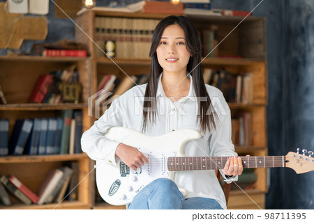 Young woman portrait (electric guitar) Young woman portrait (electric guitar) 98711395