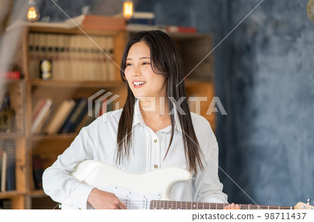 Young woman portrait (electric guitar) 98711437