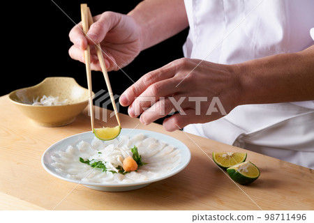 Chef serving thinly sliced tiger pufferfish 98711496