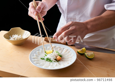 Chef serving thinly sliced tiger pufferfish 98711498