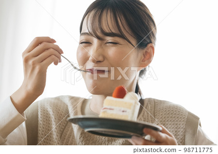 A woman eating short cake 98711775