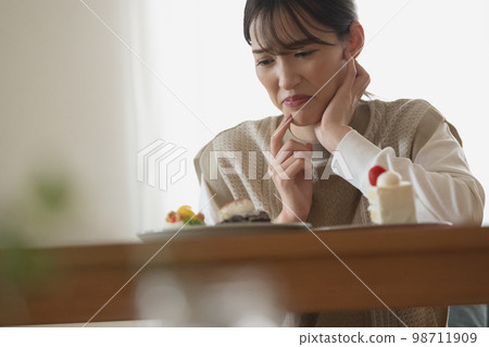 A woman on a diet who wants to eat cake but endures 98711909