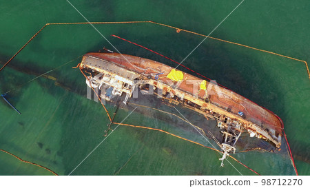Aerial top view of overturned broken rusty oil tanker ship in the shallow water. Drowned ship after the wreck. 98712270