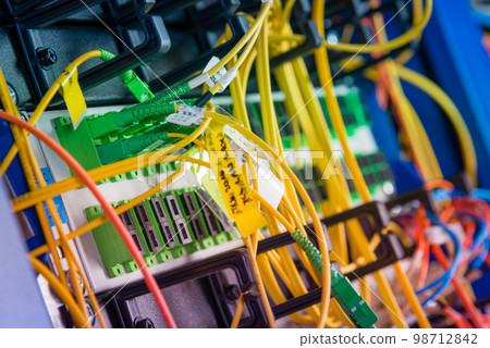 detail of server rack with fiber optic cables attached to front panel switch ports 98712842