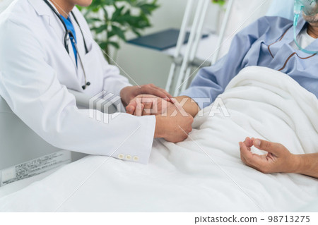 doctor taking patient's pulse 98713275