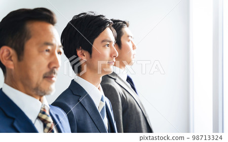 Businessmen of a wide range of generations looking into the distance Businessmen of a wide range of generations looking into the distance 98713324