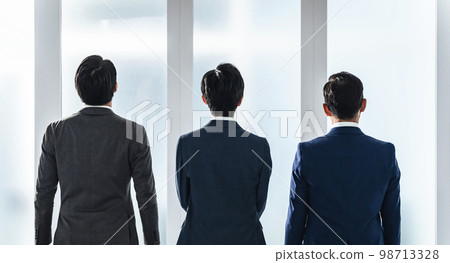 Businessmen of a wide range of generations looking out the window Businessmen of a wide range of generations looking out the window 98713328