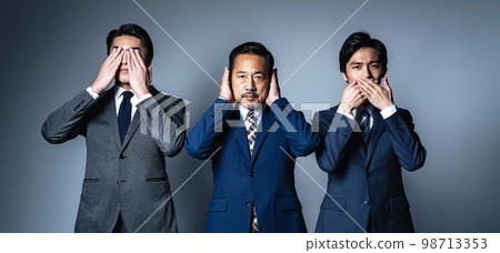 商人遮住他的眼睛、耳朵和嘴巴。 商人遮住他的眼睛、耳朵和嘴巴。 98713353