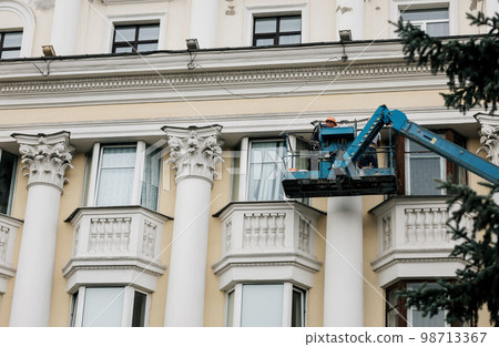 Worker in cradle of crane Worker in cradle of crane 98713367