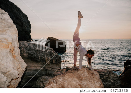 Young woman with black hair, fitness instructor in pink leggings 98713886