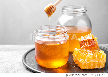 Tasty fresh aromatic honey on grey table 98714143