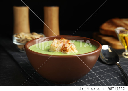 Delicious broccoli cream soup served on black table Delicious broccoli cream soup served on black table 98714522