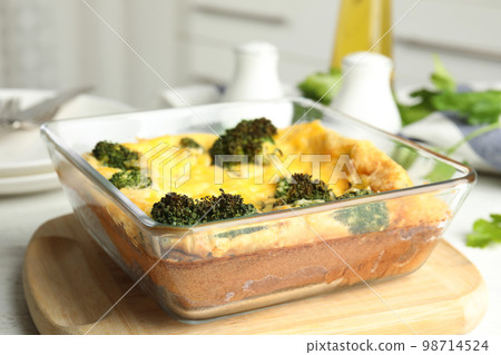Tasty broccoli casserole in baking dish on wooden board, closeup Tasty broccoli casserole in baking dish on wooden board, closeup 98714524