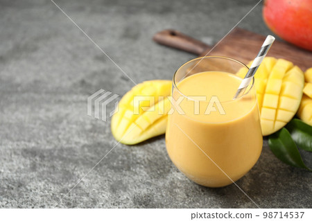 Fresh delicious mango drink on grey table. Space for text 98714537
