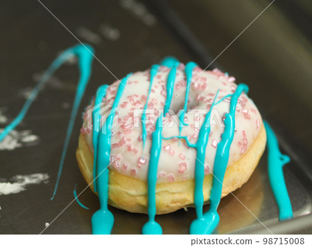 hand pastry chef designer preparing a donut for frosted white cake hand pastry chef designer preparing a donut for frosted white cake 98715008
