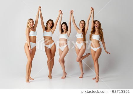 Body-positivity. Studio portrait of cheerful beautiful five women posing in underwear over grey background. Self-care. Concept of natural beauty, body care 98715591