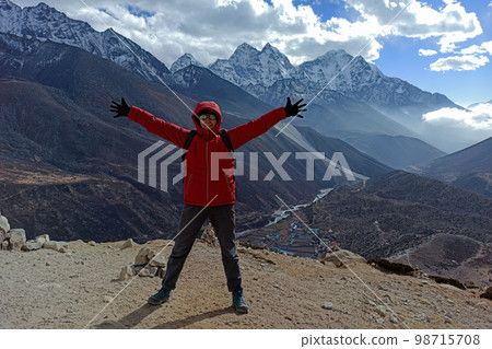 Hiker woman posing with mountains at background 98715708