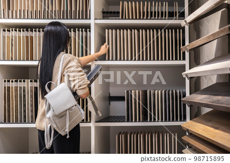 Brunette woman professional interior designer select samples ceramic tiles and grout epoxy color 98715895