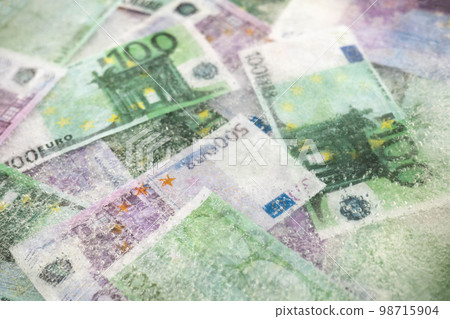 Blurred photo of one hundred and five hundred euros are defrosted in ice. The European cash currency is frozen. Blurred photo of one hundred and five hundred euros are defrosted in ice. The European cash currency is frozen. 98715904