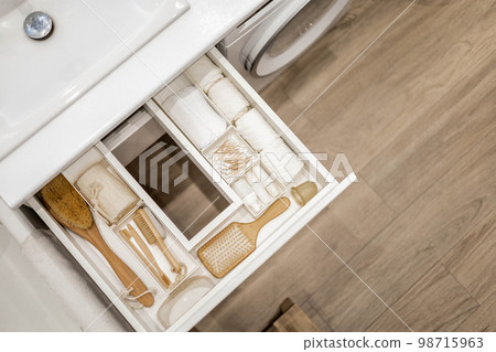 Bathroom under sink organizer drawers with neatly placed bath amenities and toiletries. Bathroom under sink organizer drawers with neatly placed bath amenities and toiletries. 98715963