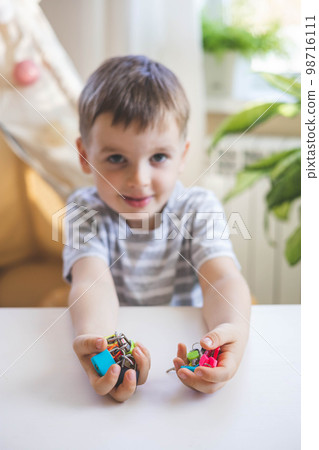 The child works with Montessori material with colored locks. Picks up keys. Develops fine motor skills. 98716111