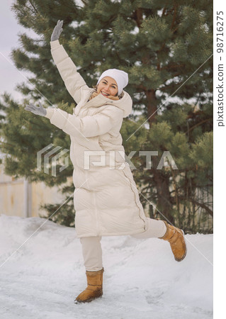 Overjoyed winter woman jumping near natural spruce with positive emotion at snowy landscape Overjoyed winter woman jumping near natural spruce with positive emotion at snowy landscape 98716275