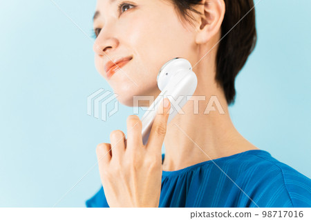 使用面部設備的年輕女性美容形象 使用面部設備的年輕女性美容形象 98717016