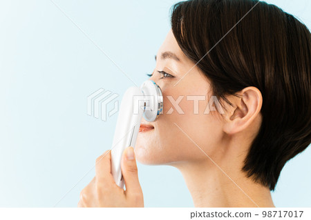 使用面部設備的年輕女性美容形象 使用面部設備的年輕女性美容形象 98717017