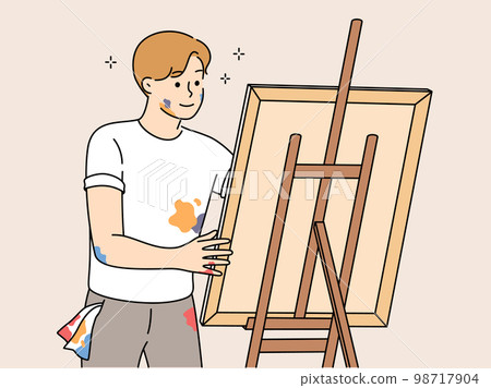 Young man drawing picture on easel  98717904