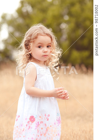 Cute little girl walking in meadow outdoor Cute little girl walking in meadow outdoor 98718002