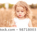 Little funny girl 2-3 year old playing in meadow. Cute child. Childhood. 98718003