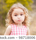 Baby girl 2-3 year old looking at camera over nature background outdoors. Childhood. 98718006