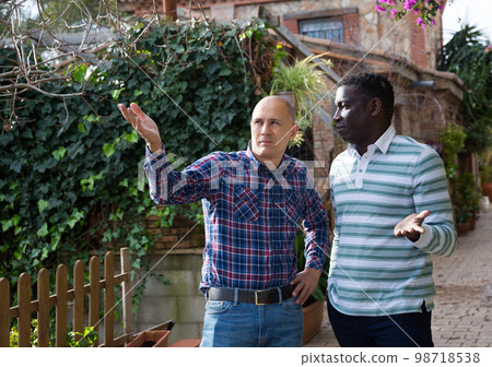 Worried farmer discussing with friend 98718538