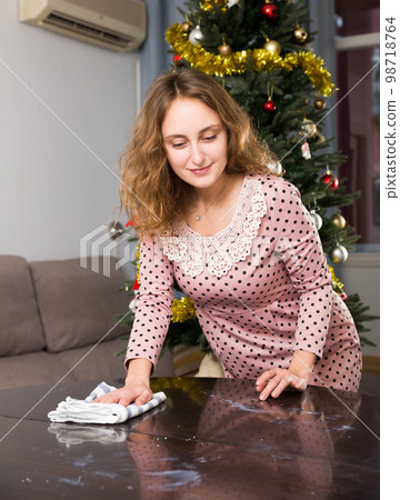 Woman wiping table before dinner Woman wiping table before dinner 98718764