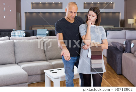 Couple choosing sofa in furniture store Couple choosing sofa in furniture store 98718902