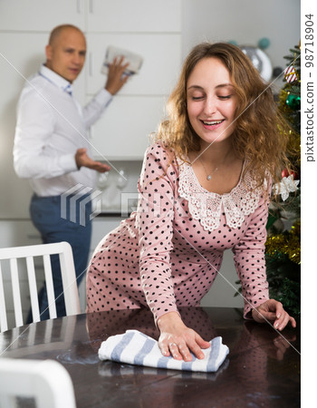 Friendly family tidying up the room before Christmas Friendly family tidying up the room before Christmas 98718904