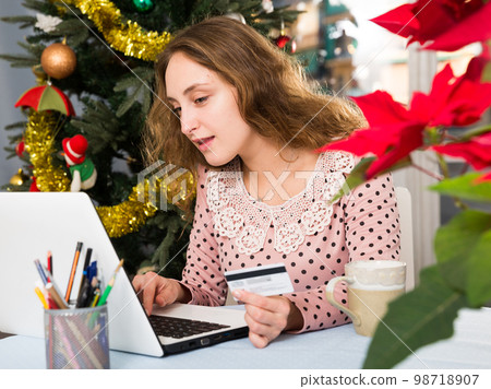 Young woman makes online shopping with credit card and laptop Young woman makes online shopping with credit card and laptop 98718907