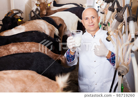 Happy veterinarian with goat milk in glass Happy veterinarian with goat milk in glass 98719260