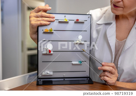 ENT doctor demostrating new hearing aid tools 98719319