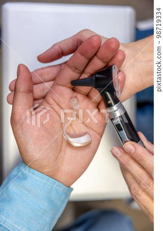 Close up of a hearing aid on males hand 98719334