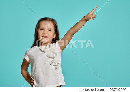 Close-up studio shot of beautiful brunette little girl posing against a blue background. 98719591