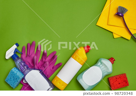 Detergents and cleaning accessories on a green background. Housekeeping concept. Detergents and cleaning accessories on a green background. Housekeeping concept. 98720348