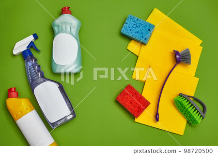 Detergents and cleaning accessories on a green background. Housekeeping concept. 98720500