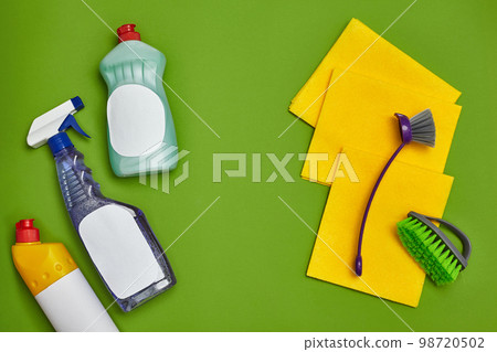 Detergents and cleaning accessories on a green background. Housekeeping concept. Detergents and cleaning accessories on a green background. Housekeeping concept. 98720502