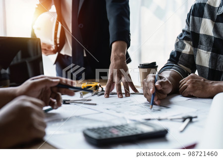 Close up of Architect team working with house model for architectural plan, engineer sketching a construction project, green energy concept Close up of Architect team working with house model for architectural plan, engineer sketching a construction project, green energy concept 98721460
