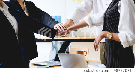 As they laugh and celebrate their performance, the business team makes a handshake motion. As they laugh and celebrate their performance, the business team makes a handshake motion. 98722071